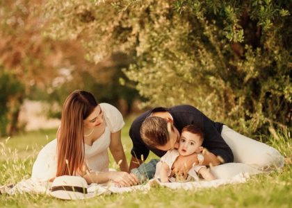A happy family having a picnic in a lush green park setting during the day.